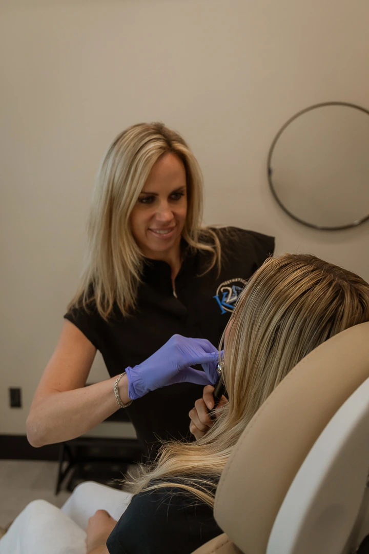 A professional applying PDO Threads treatment on a female patient’s face