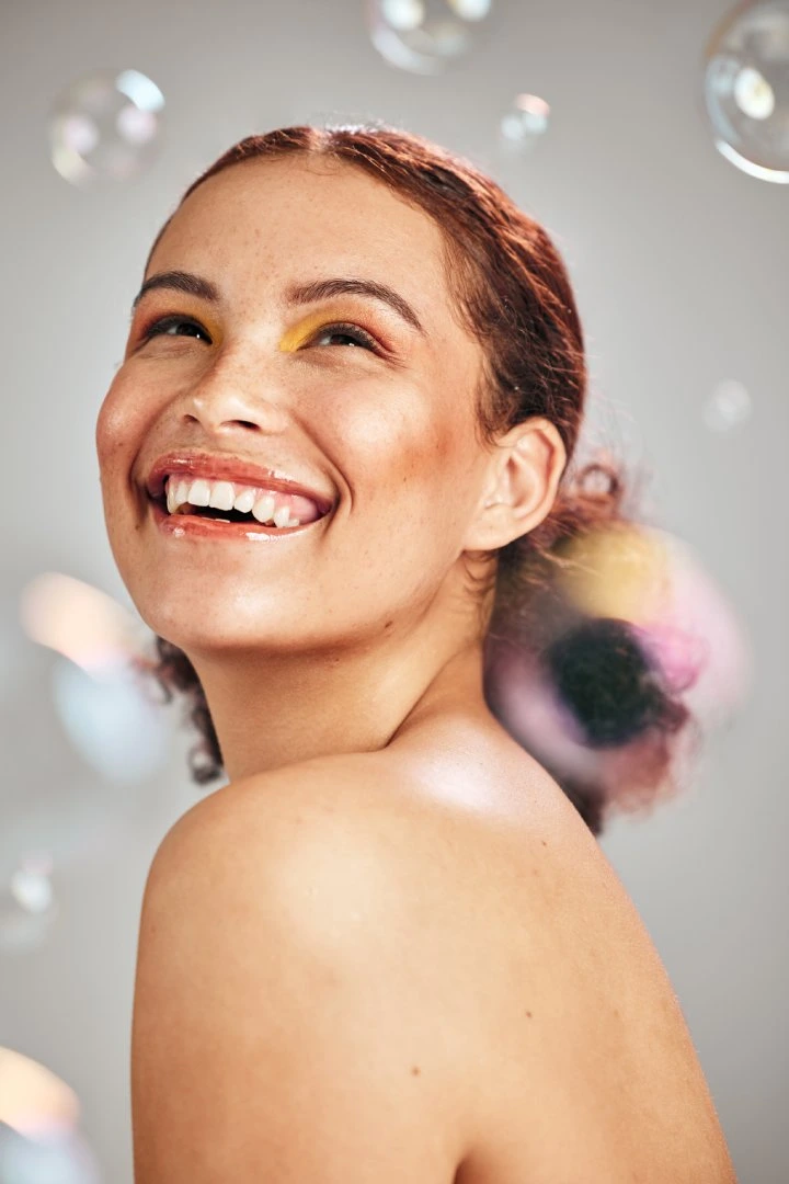Smiling woman with radiant skin enjoying benefits of Peptide Therapy