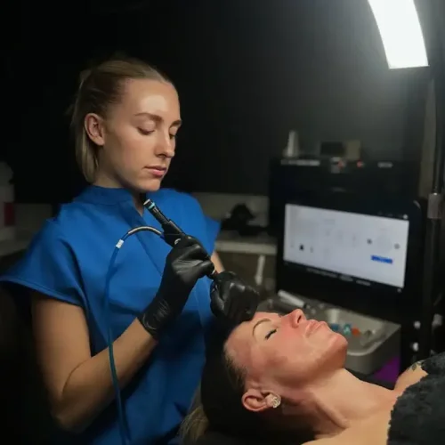 Professional performing HydraFacial treatment on woman in spa setting